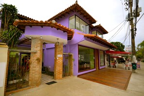 Un bâtiment à deux étages, à la façade violette et au toit recouvert de tuiles.