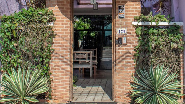 A two-story building with a tiled roof and a brick entrance. - Pousada do Centro (Búzios)