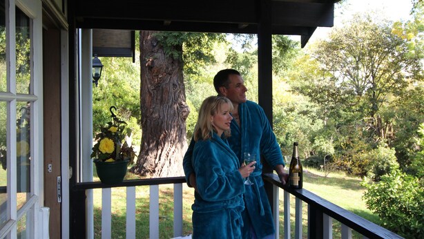A covered porch with a view of a garden and trees. - Olinda Country Cottages (Olinda)
