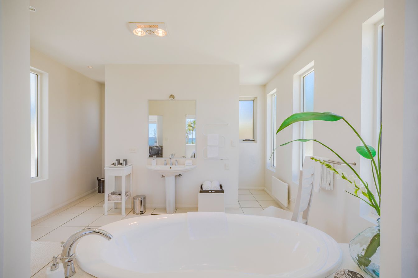 Un baño moderno con una bañera grande, un lavamanos y un espejo.
