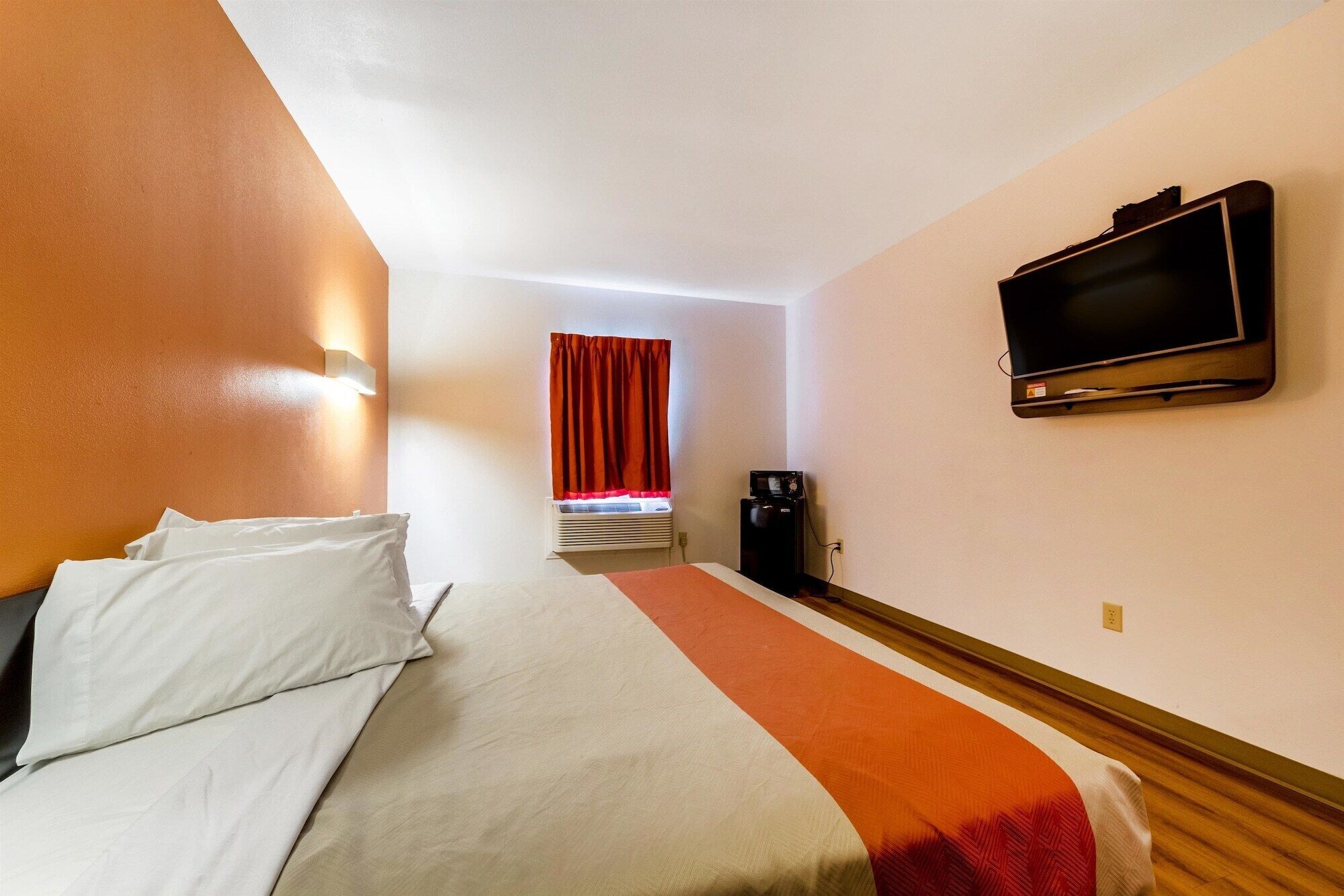 A hotel room with a bed, a television, and a coffee machine.