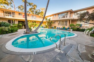 Una piscina al aire libre, sillones reclinables de piscina