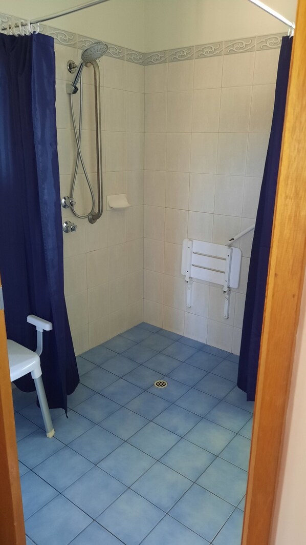 Un baño con ducha, inodoro y lavamanos.
