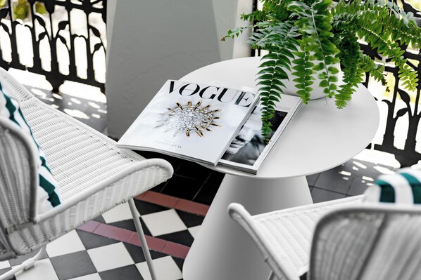 A magazine on a table with a plant beside it. - Hotel Challis Potts Point (Potts Point)