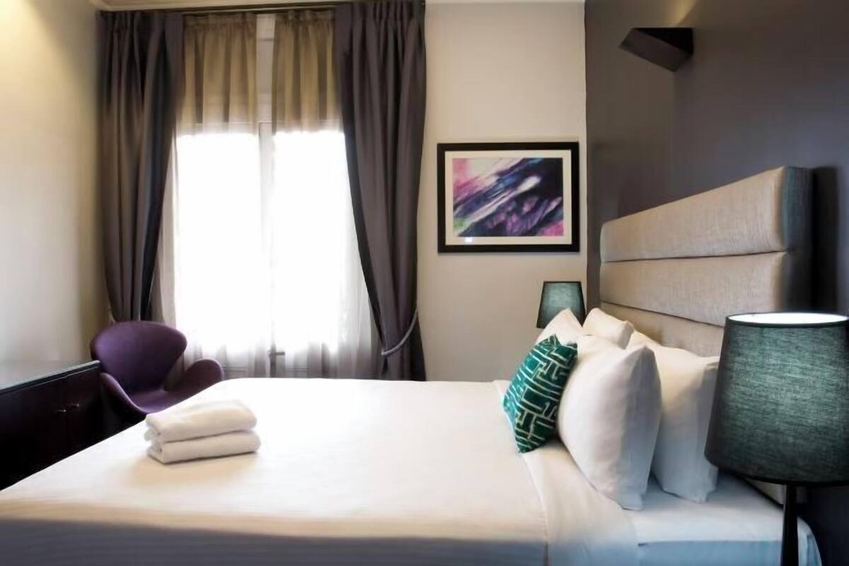 Premium bedding, desk, laptop workspace, blackout drapes