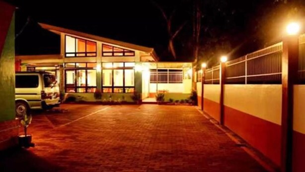 A two-story building with a driveway leading to a gated entrance.