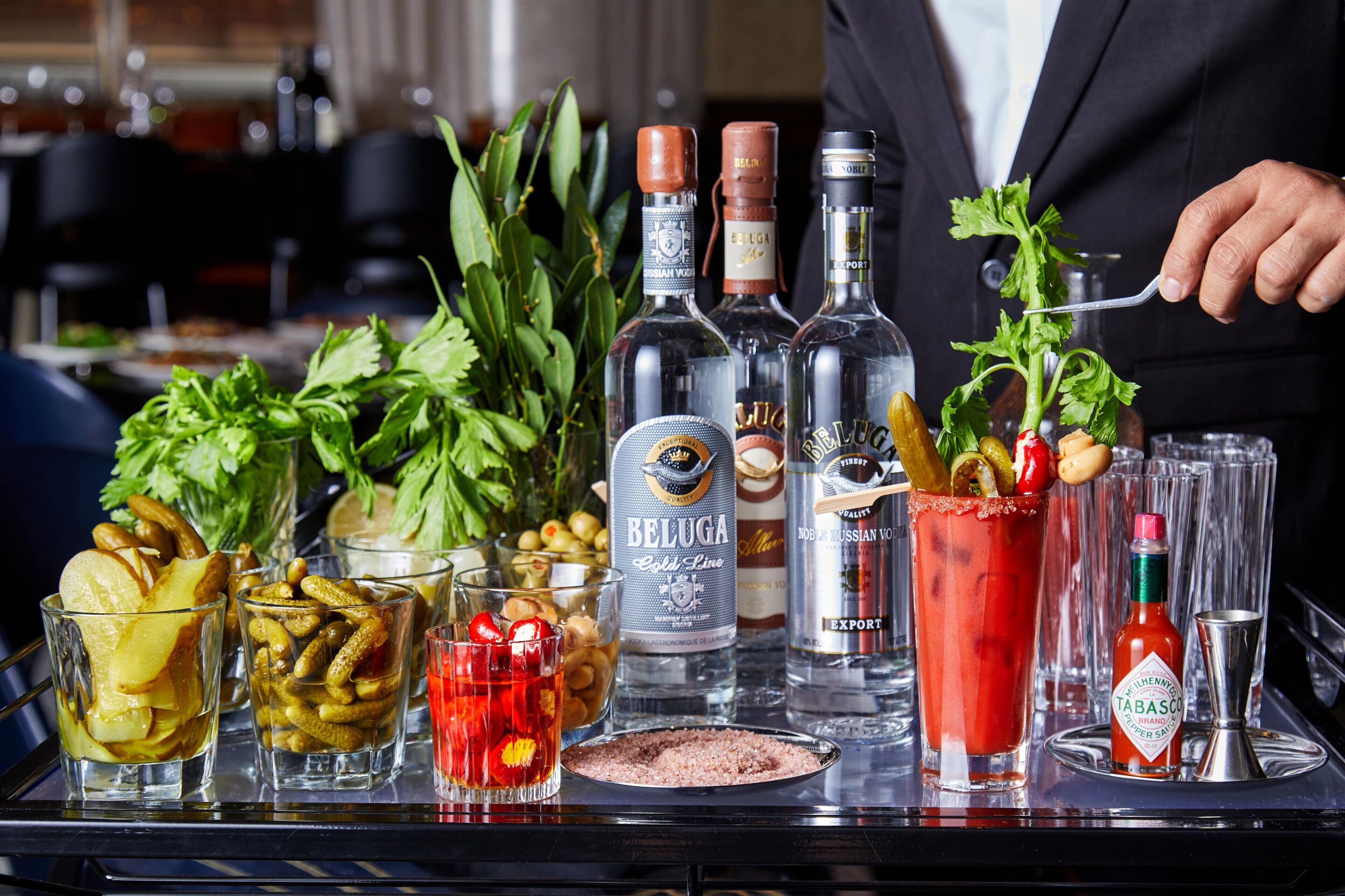 A bar setup with various bottles, glasses, and garnishes.