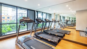 A gym with treadmills, exercise bikes, and a large mirror reflecting the space. - Livotel Hotel Kaset Nawamin Bangkok (Bangkok)