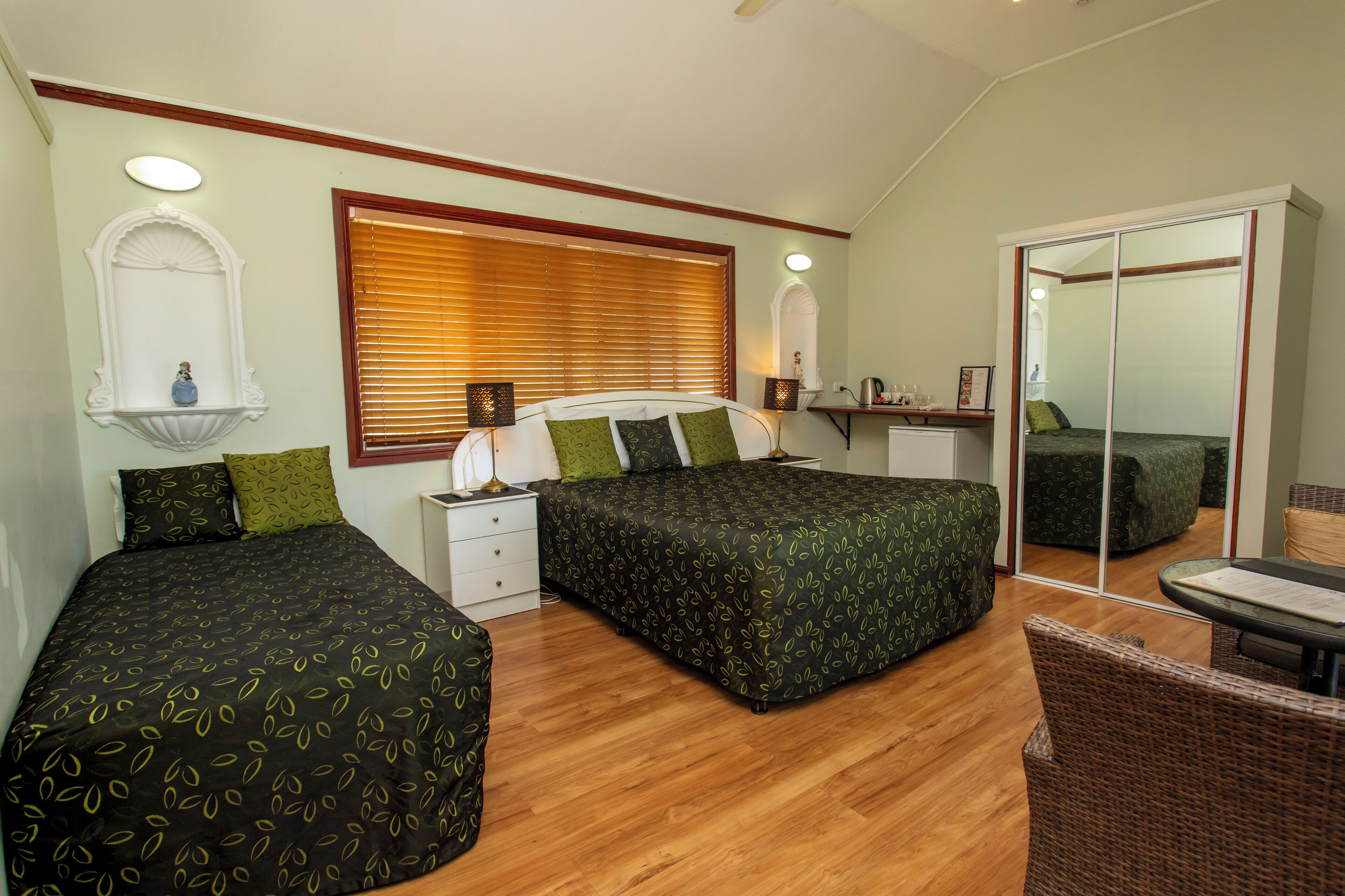A bedroom with two beds, a nightstand, a dresser, and a chair.