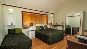 A bedroom with two beds, a nightstand, a dresser, and a chair.