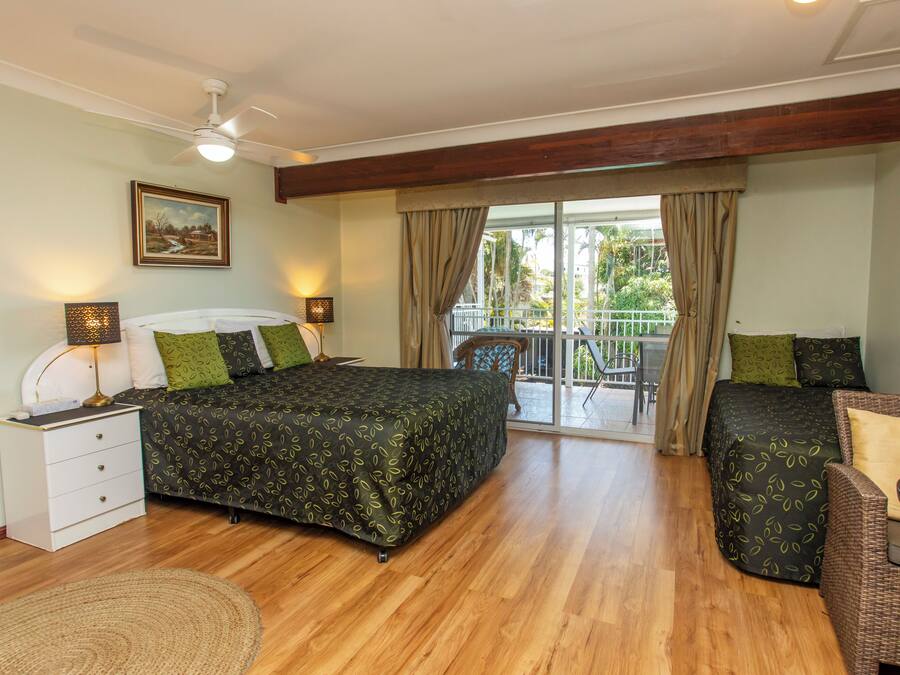 Ein Schlafzimmer mit Bett, Nachttisch, Stuhl und einem Balkon mit Blick.
