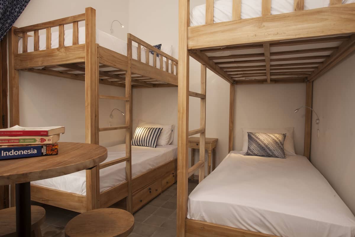 Ett rum med våningssängar, ett litet bord och en stol. Det ligger böcker på bordet.