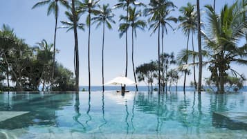 Piscina externa, piscina infinita, guarda-sóis, espreguiçadeiras