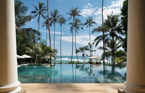 A pool with palm trees and a view of the ocean. - Eraeliya Villas & Gardens (Weligama)