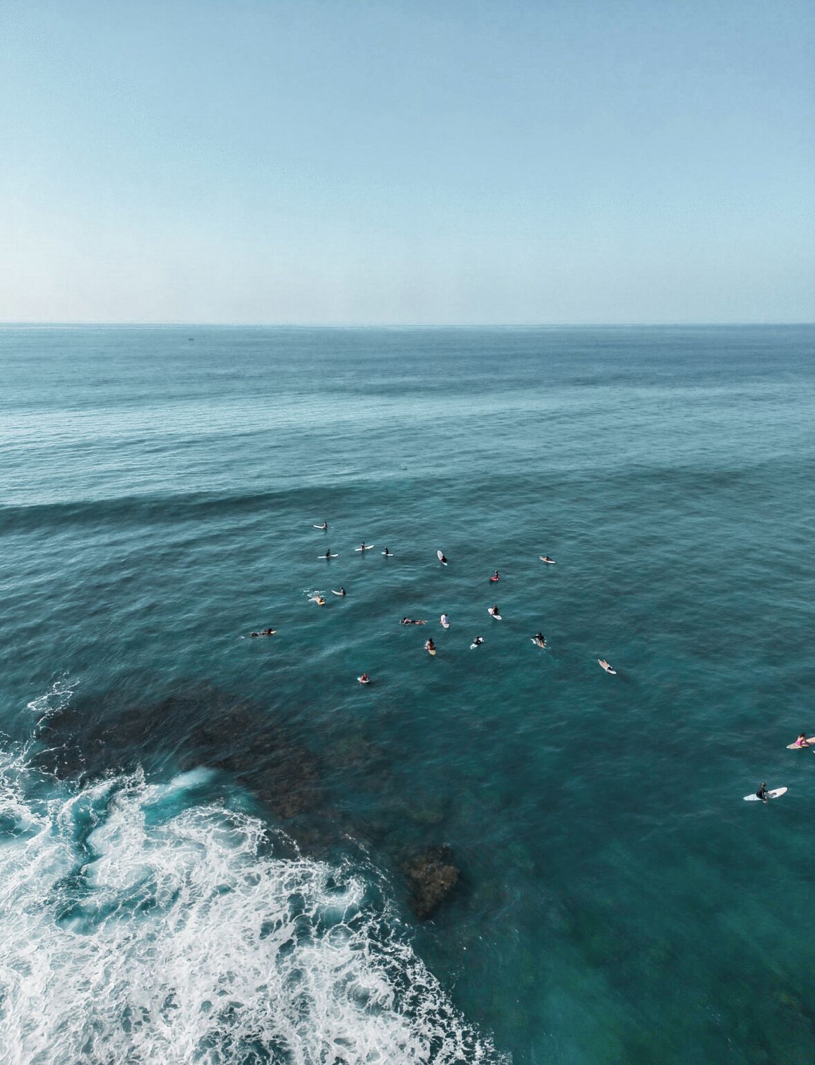 A coastal view with surfers in the water.