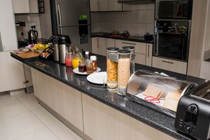Chambre luxueuse double | Cuisine partagée | Réfrigérateur, micro-ondes dans les aires communes, cafetière-théière