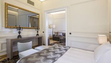 Una habitación de hotel con una cama grande, un tocador con espejo, un escritorio y un sofá al fondo.