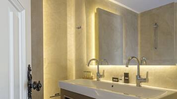 A modern bathroom with a double sink, a large mirror, and a shower.