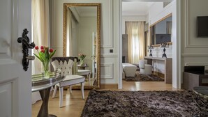 A spacious living room with a large mirror, a tufted sofa, and a modern fireplace. - 3Sixty Hotel & Suites (Nafplio)