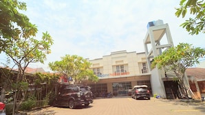 A hotel with a tiled entrance, a signboard, and a modern building structure. - CityOne Xpress Semarang (Semarang)