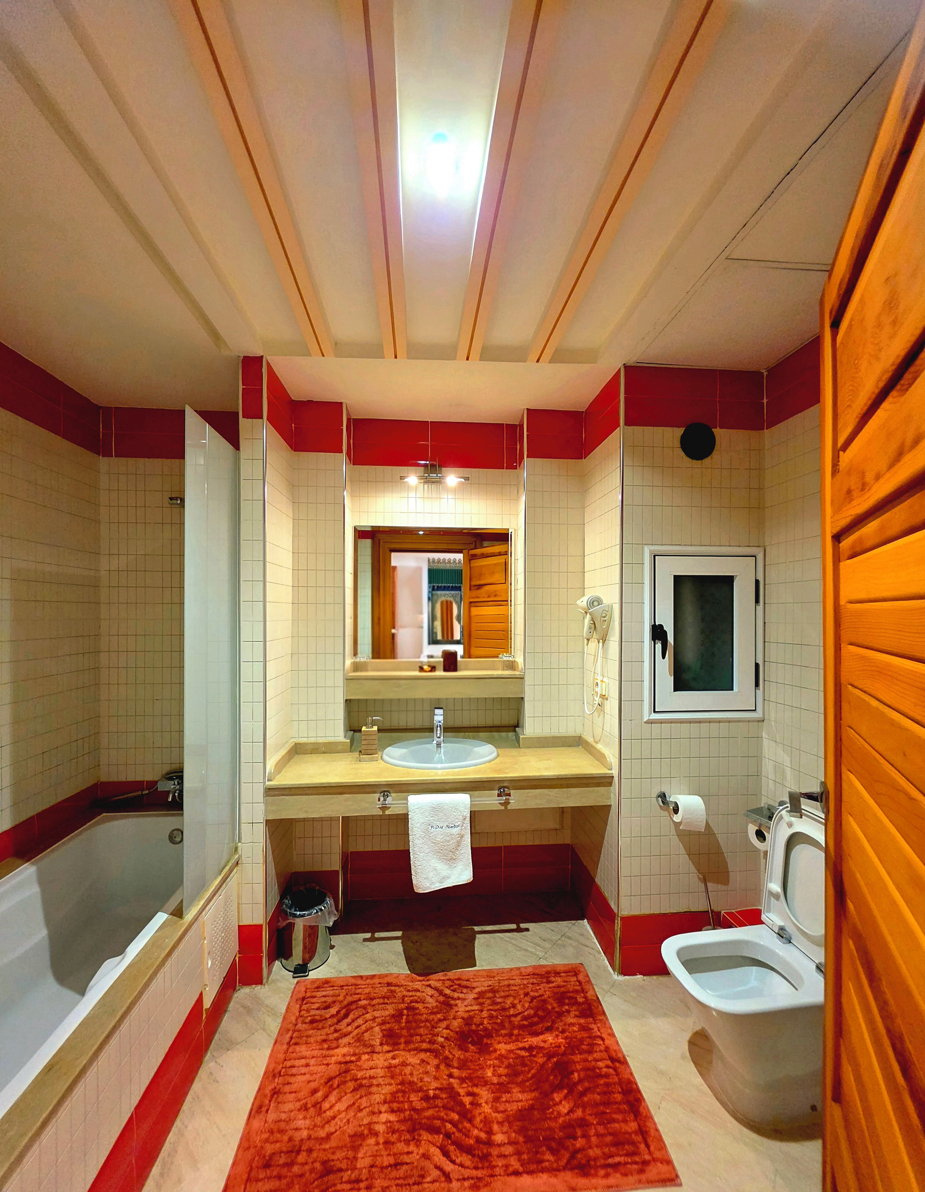 Un baño con bañera, lavamanos, espejo, inodoro y ducha.