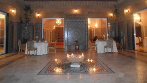 A spacious lobby with a central fountain, ornate walls, and multiple seating areas.