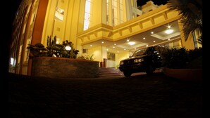 A hotel with a grand entrance, a car parked in front, and a well-lit facade at night. - Grand Wahid Hotel Salatiga (Salatiga)