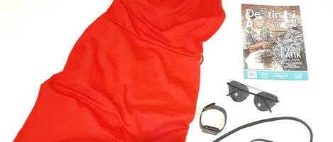 Um vestido vermelho, salto alto bege, uma bolsa preta e um par de óculos de sol.