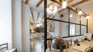 A modern kitchen with wooden beams, a large window, and a dining area with a table and chairs. - Cas'E Charming House (Caserta)