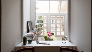 A room with a window overlooking a courtyard, a desk with a lamp, books, and a cactus. - Cas'E Charming House (Caserta)