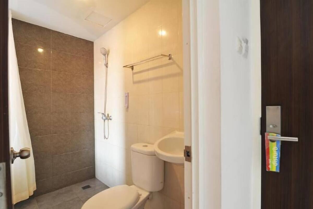 A small bathroom with a toilet, sink, and shower.