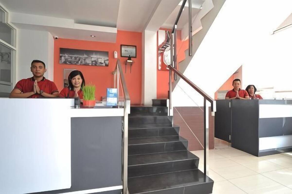 A reception area with a staircase, a reception desk, and a wall-mounted clock.