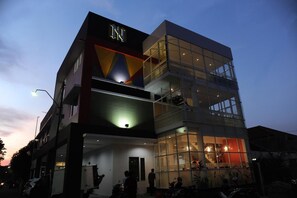 A modern hotel with a glass facade, multiple floors, and a prominent 'INN' sign. - Nozz Hotel Semarang (Semarang)