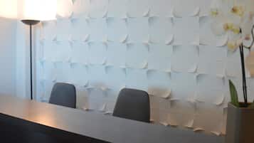 A reception area with a modern design, featuring a textured wall and a reception desk.