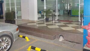A building entrance with glass doors, a checkered floor, and a parked car. - Cordex Hotel Ancol Jakarta (Jakarta)