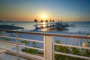A pier extending into calm waters at sunset, with a railing and potted plants in the foreground. - Ocean View Residence - Hotel Jepara (Jepara)