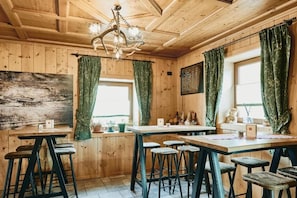 A wooden interior with a bar area, wooden ceiling, and green curtains. - Albergo 2000 (Livigno)