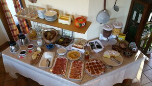 A buffet table with various food items and utensils.