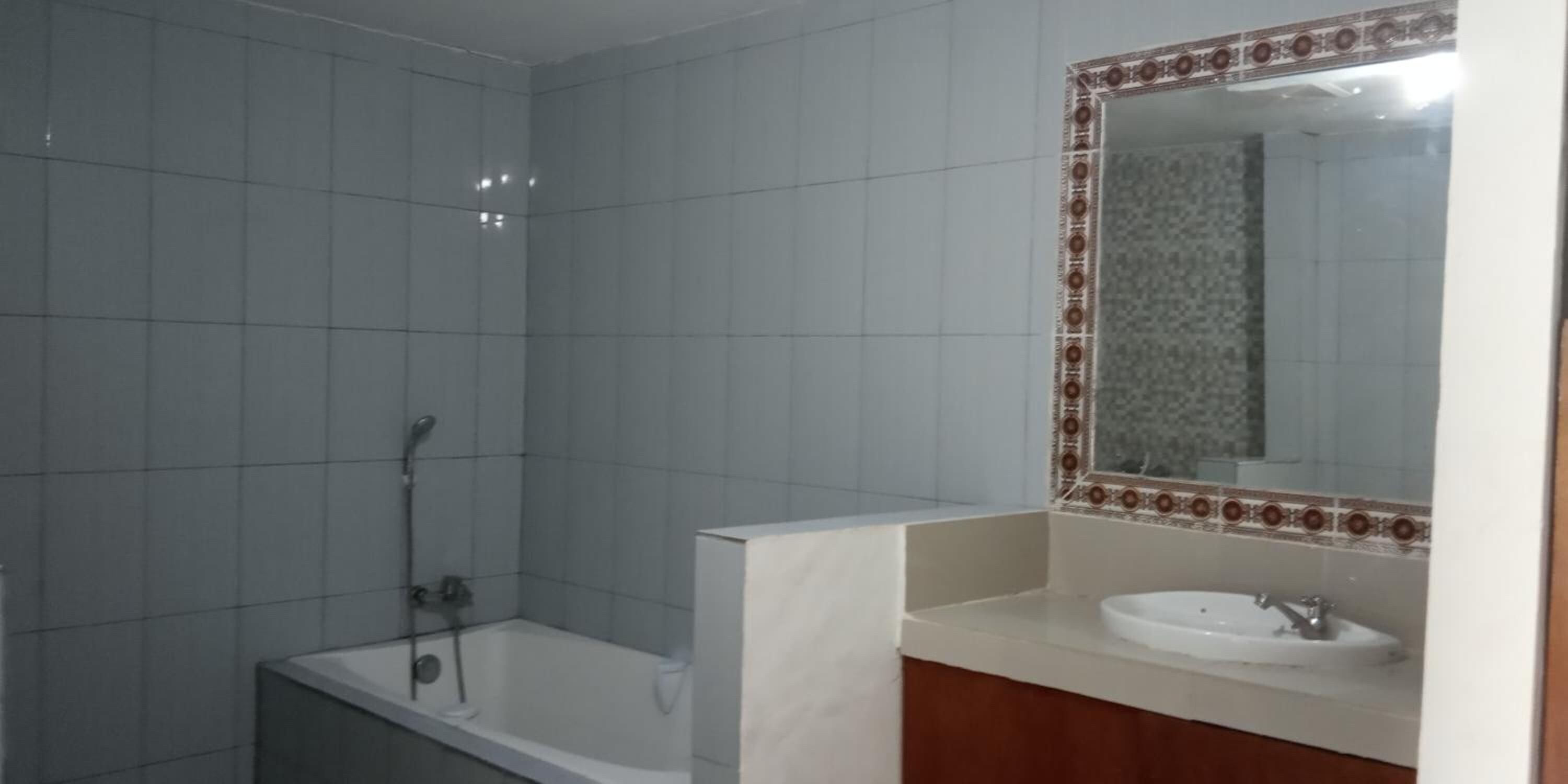A bathroom with a shower, a sink, and a mirror.