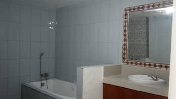 A bathroom with a shower, a sink, and a mirror.