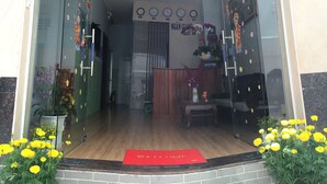 L’entrée de la maison d’hôtes Ngân Giang, avec un comptoir d’accueil, des horloges et un tapis rouge.