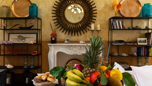 Una habitación con chimenea, un espejo y estanterías con libros y objetos decorativos.