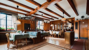 A spacious dining area with wooden beams, multiple tables, and chairs. - Landgasthaus Pfahl (Wershofen)
