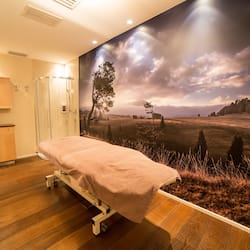 Relax in a serene space with a large wall mural and a comfortable bed.