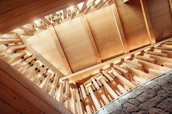 Interior de madera con techo inclinado y suelo de piedra.