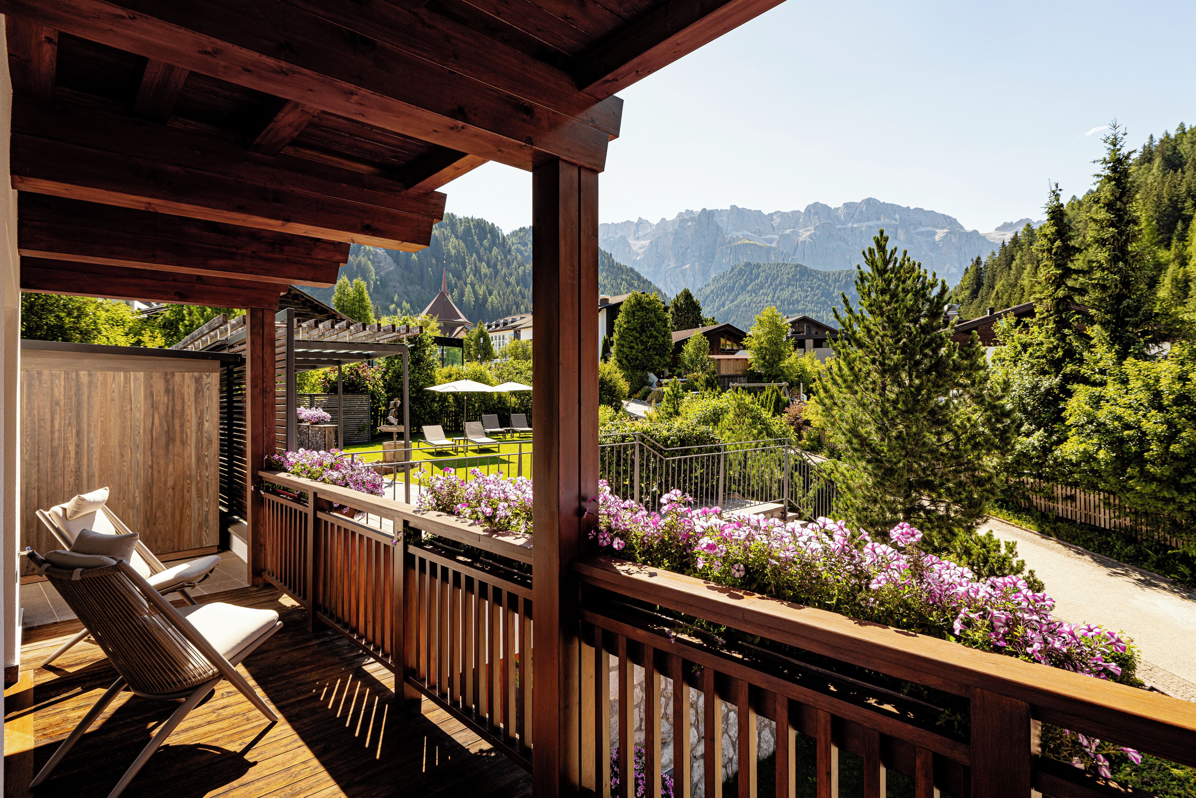 A wooden deck with outdoor seating and a view of a mountainous landscape.
