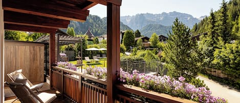 A wooden deck with outdoor seating and a view of a mountainous landscape.