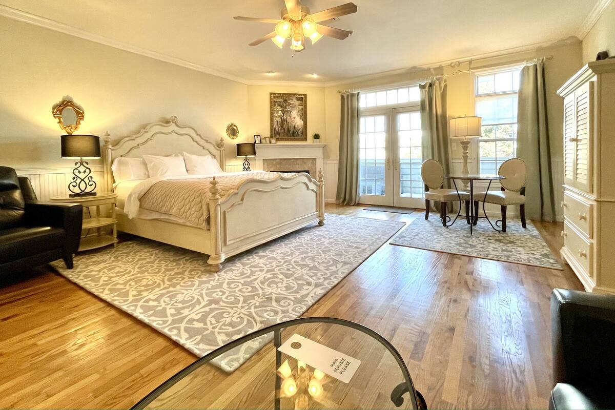 A bedroom with a bed, bedside tables, a desk, and a chair.