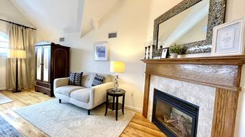 A living room with a fireplace, a sofa, a lamp, and a cabinet.