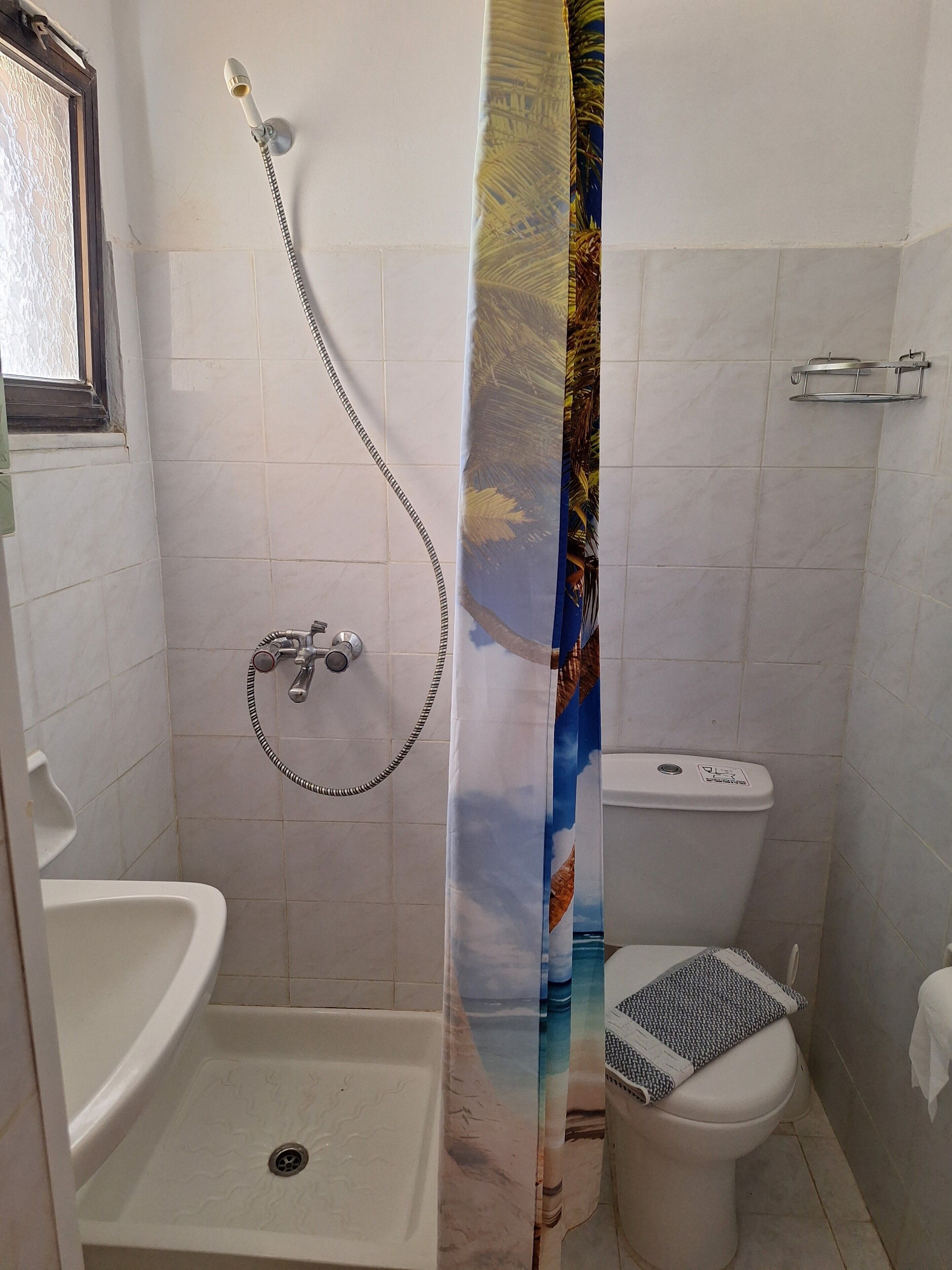 Un baño con ducha, inodoro y lavamanos.